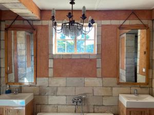 a bathroom with two sinks and a chandelier at La Locanda in Ruhengeri