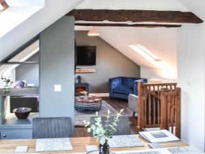 a dining room and living room with a vaulted ceiling at Drovers Barn in Penrith