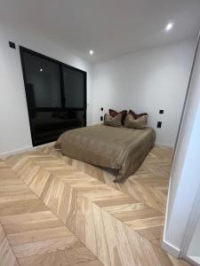 1 dormitorio con 1 cama y suelo de madera en Les Trois Cyprès, en Blois