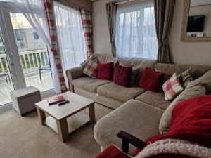 a living room with a couch and a table at Mini lodge hot tub hols at Kingfisher Court in Tattershall