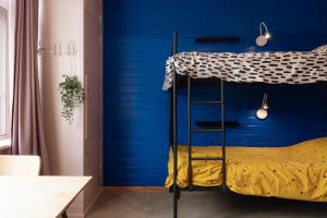 a bedroom with a blue wall and a bunk bed at Hostel Ani&Haakien in Rotterdam