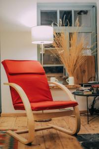 a red chair in a living room with a table at JorJ'Inn in Lentekhi