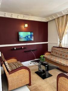 a living room with two couches and a table at Appartement New Stading YAOUNDE - MIMBOMAN MAETURE in Yaoundé