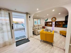 a living room with a yellow chair and a couch at P.EMPORDA 30 BJ in Empuriabrava