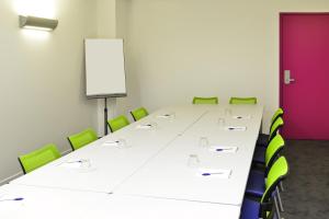 モンテリマールにあるibis Styles Montelimar Centreの会議室(長いテーブル、緑の椅子付)
