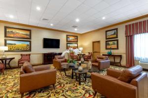 una sala de espera con muebles y TV de pantalla plana. en Hawthorn Suites by Wyndham West Palm Beach en West Palm Beach