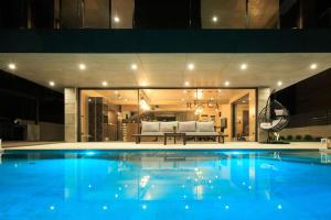 a large swimming pool in a house with a couch at Villa Besca with heated infinity pool in Baška