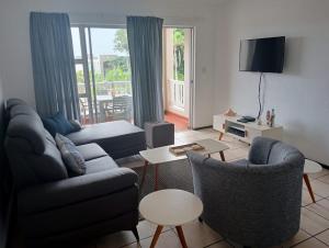 a living room with a couch and chairs and a television at Laguna La Crete 163 in Margate