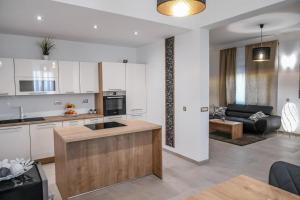 a kitchen and living room with white cabinets and a couch at Villa Isabella in Opatija