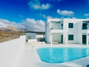 uma casa branca com uma piscina em frente em CIH Apartments em Puerto del Carmen