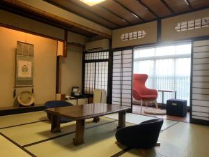 ein Zimmer mit einem Tisch und Stühlen in einem Zimmer in der Unterkunft Koyado Enn in Toyooka