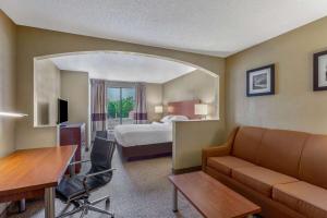 a hotel room with a bed and a couch and a desk at Days Inn by Wyndham Blairsville in Blairsville