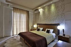 a bedroom with a large bed and a large window at Saint Amon Hotel in Faliraki