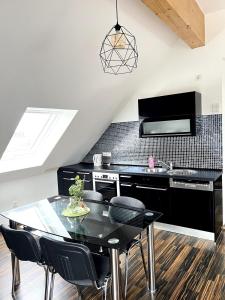 uma cozinha com uma mesa preta e cadeiras pretas em Amazing & design 2-room apartment near Cologne em Trompete