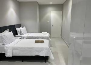 1 Schlafzimmer mit 2 Betten und einer Glasdusche in der Unterkunft Apartamento moderno em Copacabana in Rio de Janeiro