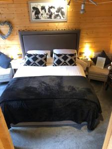 Beauslodge Authentic Log Cabin With Private Hot Tub في Arford: غرفة نوم بسرير كبير في غرفة