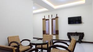 a living room with a table and chairs and a tv at Omah Pikatan Homestay in Jarakan