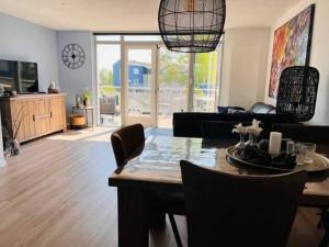 a living room with a dining room table with chairs at Vakantiehuis, Kaaidijk 42 Kortgene in Kortgene