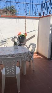 un tavolo con due sedie e un tavolo con fiori di La Rosa Dei Venti a Villa San Giovanni