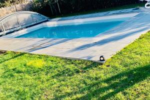 a swimming pool in the grass with a car next to it at Time Stops Here At Home in Saint-Hilaire-de-Riez