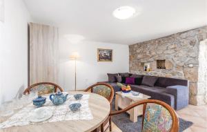 a living room with a table and chairs and a couch at Amazing Home In Moscenicka Draga With 4 Bedrooms And Wifi in Mošćenička Draga