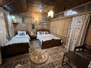 um quarto com duas camas e uma mesa em Young Shahzada Group of Houseboats em Srinagar