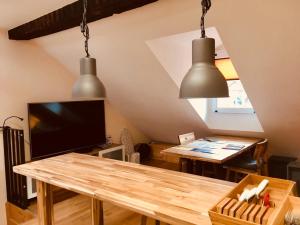 ein Wohnzimmer mit einem Tisch und zwei Hängelampen in der Unterkunft Apartments Aarbergergasse in Bern