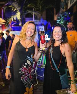 two women standing next to each other at a party at ÔVibe Party Hostel in Belém
