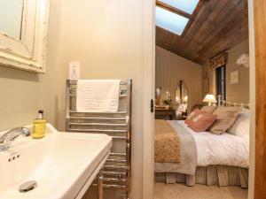 un bagno con lavandino e un letto in una camera di The Badger's Shack a Kendal