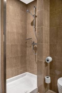 a bathroom with a shower with a tub and a toilet at Danai Hotel & Spa in Olympic Beach