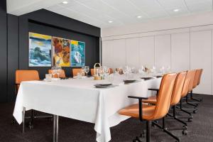 una sala conferenze con un grande tavolo bianco e sedie di Comwell H C Andersen Dolce by Wyndham a Odense