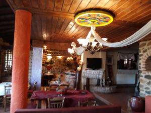 uma sala de jantar com uma mesa e um lustre em Iaspis Guesthouse em Sidhirokhórion
