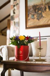 a red pot on a table with flowers on it at Hunter Prince Castle Hotel in Turda