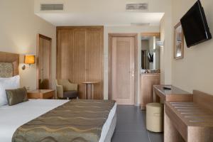 a hotel room with a bed and a television at Danai Hotel & Spa in Olympic Beach