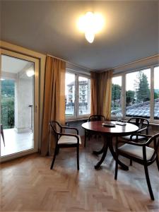 a dining room with a table and chairs and windows at Apartament u Tomka Premium in Ustrzyki Dolne