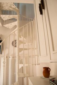 a white spiral staircase in a white room at Sotza’s Little House in Padru