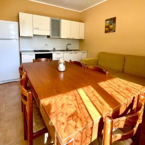 een keuken met een houten tafel en een bank bij Residence il Faro in Marina di Monasterace