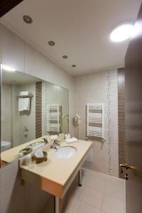 a bathroom with a sink and a large mirror at Hotel Art in Buzau