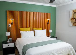 um quarto com uma cama grande com paredes amarelas e verdes em Mint Guesthouse em Randfontein