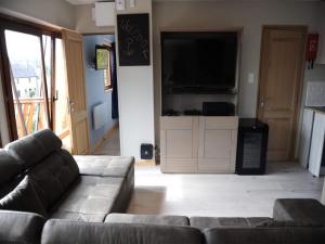 ロシュフォールにあるChalet in Rochefort with Garden BBQのソファと薄型テレビのあるリビングルーム