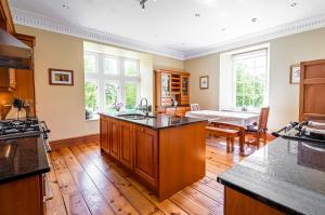 a kitchen with a large island in a room at Assynt House 5 Star Exclusive Use Venue in Dingwall