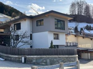 a white house with a fence in front of it at Mi's Apartment in Matrei am Brenner