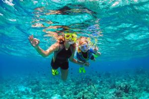 two people swimming in the water in the ocean at Danat Jebel Dhanna Resort in Jebel Dhanna