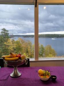 a bowl of fruit on a table in front of a window at Archipelago villa, cabin & sauna jacuzzi with sea view, 30 minutes from Stockholm in Tyresö