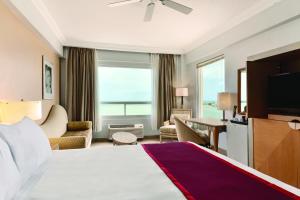 a hotel room with a large bed and a television at Ramada by Wyndham Princess Belize City in Belize City