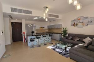 sala de estar amplia con sofá y cocina en One Bedroom Apartment Muscat Bay, en Mascate