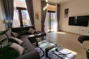 sala de estar con sofá y mesa de cristal en One Bedroom Apartment Muscat Bay, en Mascate