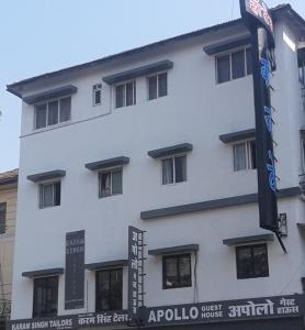 a white building with a sign in front of it at Apollo Guest House in Mumbai