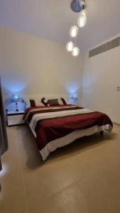 een slaapkamer met een bed in een witte kamer bij One Bedroom Apartment Muscat Bay in Muscat