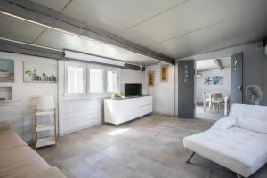 a living room with a white couch and a table at Luxury Bungalow in Villaggio Azzurro